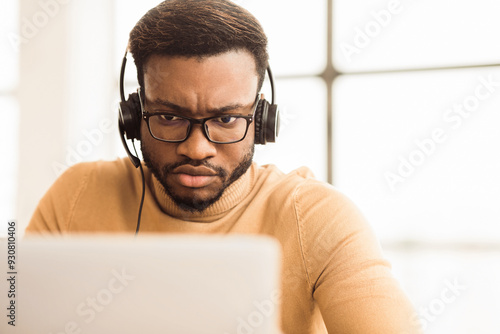 Tech Support. Focused black male helpline operator in headset working in customer care support office, copy space
