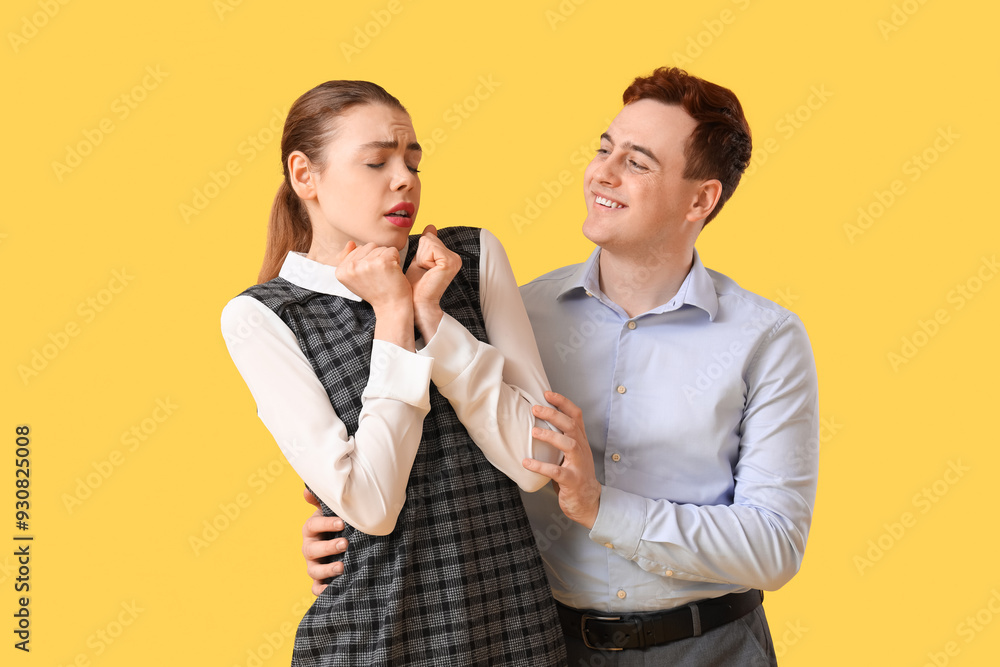 Business man molesting to his female colleague on yellow background. Harassment concept Business man molesting to his female colleague on yellow background. Harassment concept