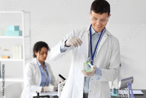 Male chemist with flask in laboratory