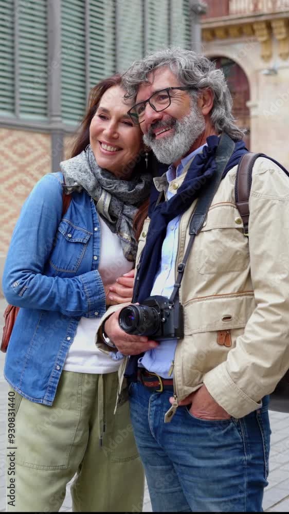 Vertical video portrait of senior tourist couple standing together at city street. Retired people bonding outdoors. Vertical video portrait of senior tourist couple standing together at city street. Retired people bonding outdoors.