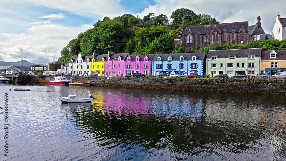 Aerial view of Portree town with colourful houses and fishing boats in Scotland. Scenic view of the natural harbour and port by high ground and cliffs. Popular tourist destination on the Isle of Skye. Aerial view of Portree town with colourful houses and fishing boats in Scotland. Scenic view of the natural harbour and port by high ground and cliffs. Popular tourist destination on the Isle of Skye.