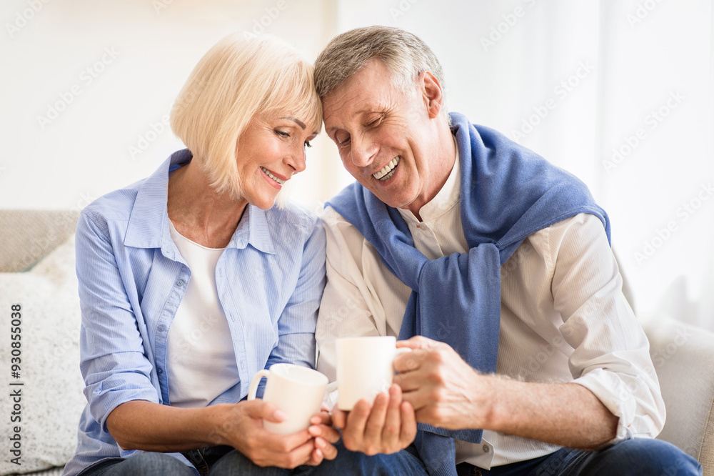 Obraz premium Tender mature couple drinking tea at autumn day, spending weekend at home