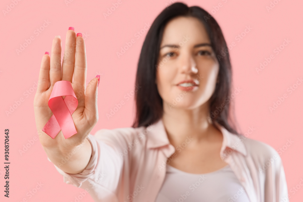 Young woman with pink ribbon on color background, closeup. Breast cancer awareness concept Young woman with pink ribbon on color background, closeup. Breast cancer awareness concept