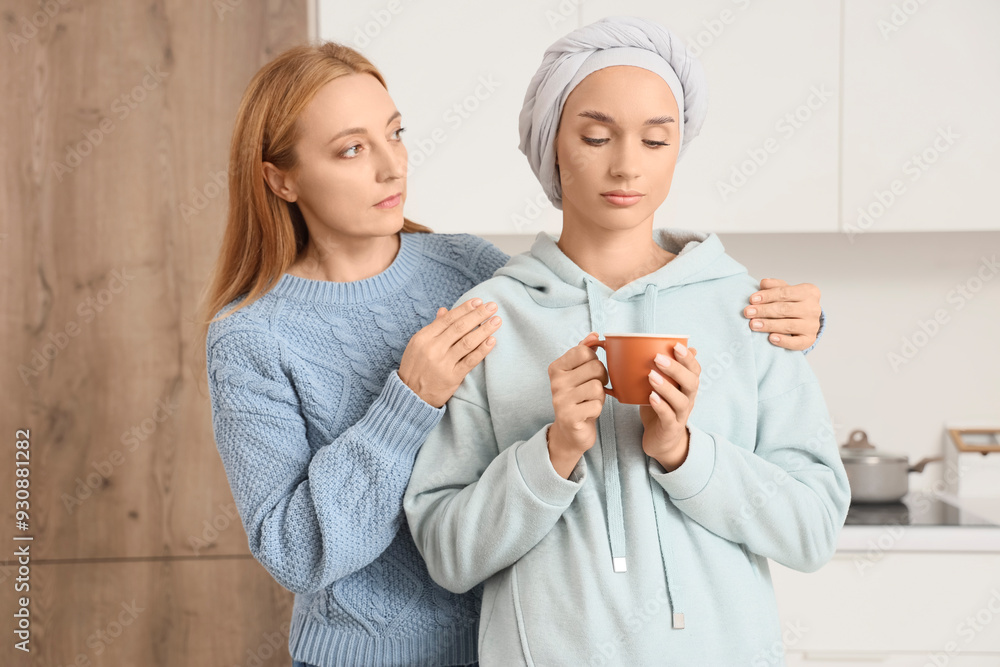 Sad young woman after chemotherapy with coffee cup and her mother in kitchen Sad young woman after chemotherapy with coffee cup and her mother in kitchen