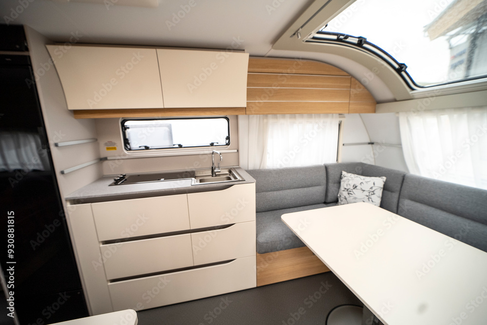 Interior with,tables,refrigerator,kitchen corners,ceiling ligthning,couches,living space in modern Slovenian camper van Adria. Interior with,tables,refrigerator,kitchen corners,ceiling ligthning,couches,living space in modern Slovenian camper van Adria.