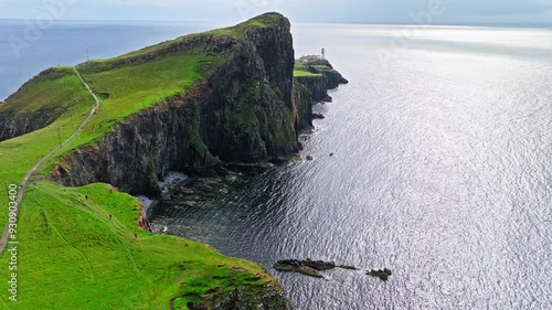 Scenic aerial view of a rocky cliff on the coastline of Scotland, United Kingdom. Scottish Highlands.Travel destination. Tourist attraction landmark Neist Point Lighthouse on Isle of Skye.