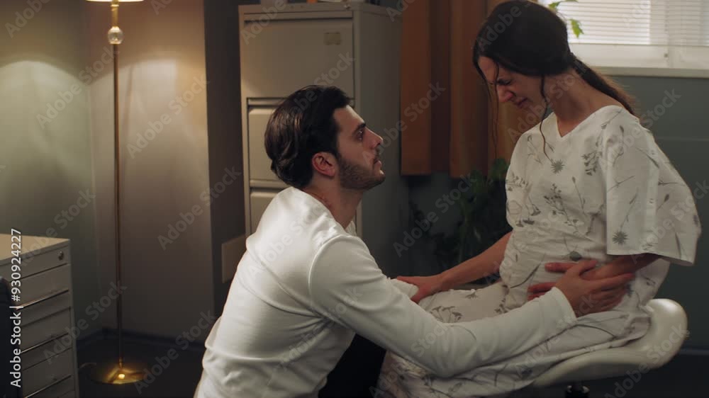 Man helping his wife while she is in pain right before childbirth Man helping his wife while she is in pain right before childbirth