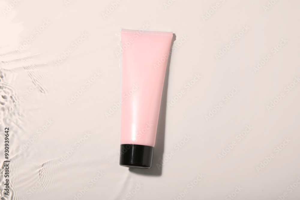 Cosmetic product. Tube with cream in water on light background, top view Cosmetic product. Tube with cream in water on light background, top view