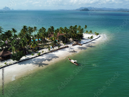 Sand peninsula with palm trees and exclusive resorts surrounded by pam trees and emerald waters in this idyllic beach of Koh Mook, Trang, Thailand photo