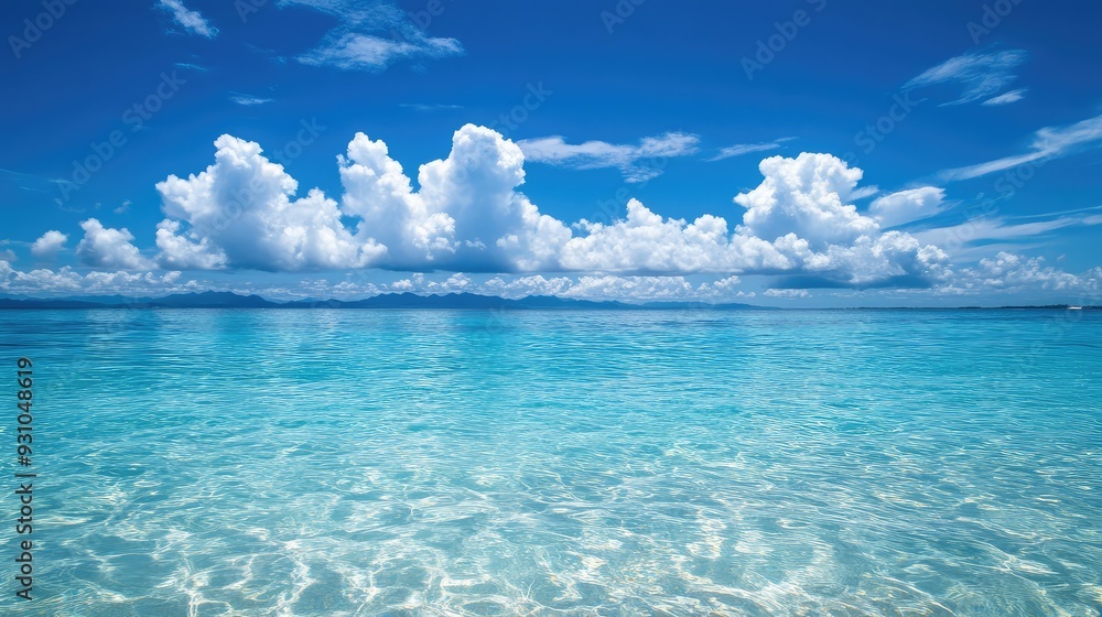 Obraz premium A shimmering crystal sea under a cloudless sky, the water so clear that you can see the ocean floor and marine life below.
