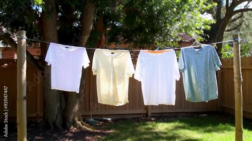 Wallpaper Mural Colorful shirts drying in the sun, highlighting domestic chores in a peaceful outdoor setting filled with greenery. Torontodigital.ca