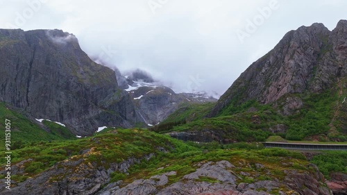 Wallpaper Mural Mountain range in Vassdalsvattnet near Reine in Lofoten Norway. Majestic mountains with rocky faces in the background. Sky is cloudy and ominous. Lush, green vegetation covers the foreground. E10 road Torontodigital.ca