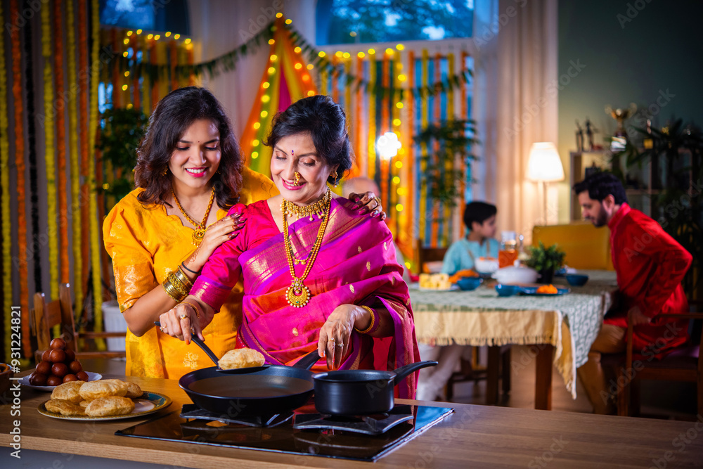 Indian old woman and young daughter in traditional cloths cooking food for Diwali festival at home Indian old woman and young daughter in traditional cloths cooking food for Diwali festival at home