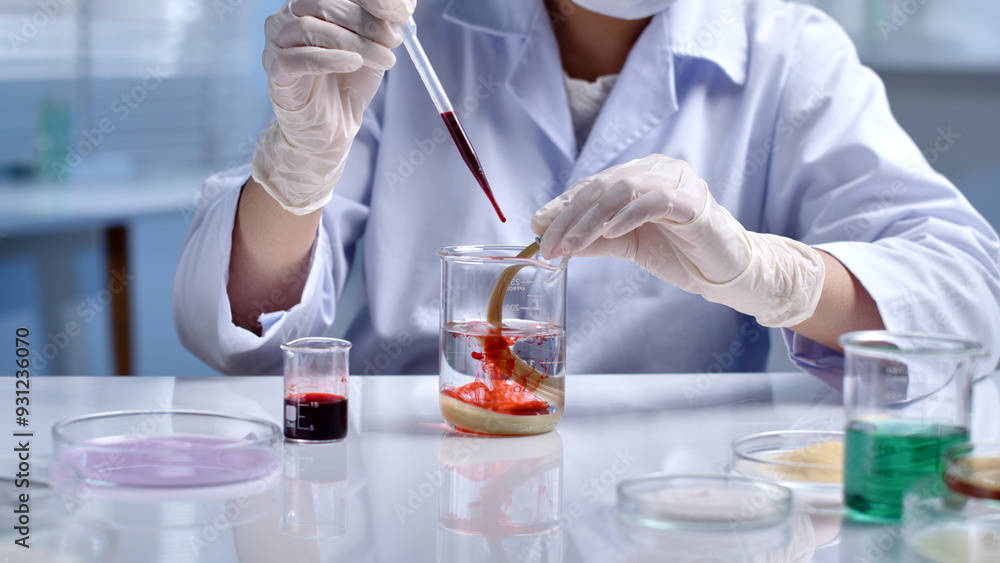 Close-up of each drop of red solution dropped by the scientist into the beaker containing the yellow damaged hair sample. Scene of hair research, experiments with hair samples Close-up of each drop of red solution dropped by the scientist into the beaker containing the yellow damaged hair sample. Scene of hair research, experiments with hair samples