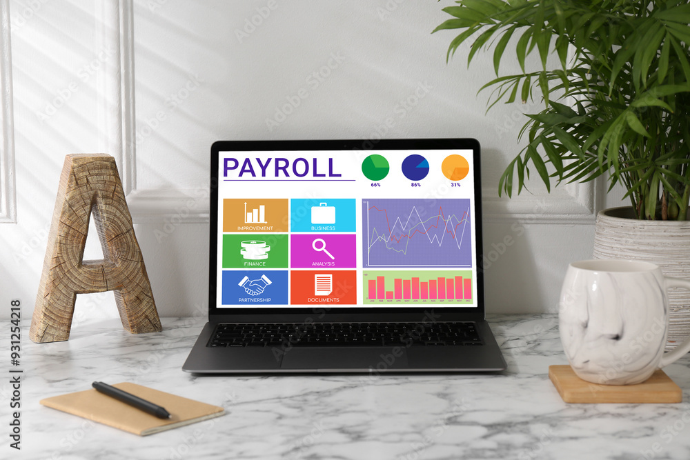 Fototapeta premium Laptop with payroll data on screen on table