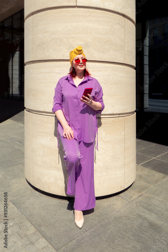 Happy and funny cool lady with fashionable clothes on dark background look to the phone with different emotions - adult asian with extravagant style, concepts about lifestyle, fasion and elderly