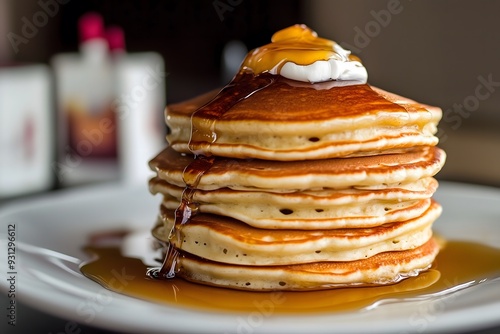 A stack of pancakes topped with syrup and whipped cream