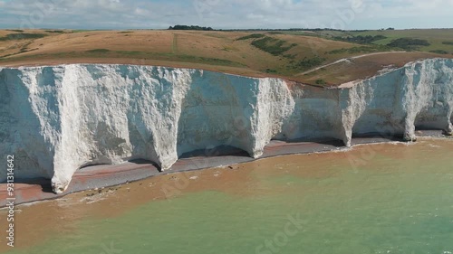 Majestic Seven sisters chalk cliffs are rising above the sea level in Newhaven, UK. The waters of the English Channel hit the shore on a sunny summer day photo