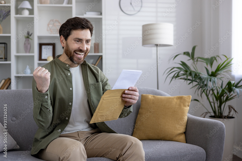 Joyful man reading letter expressing excitement and success. Holding envelope, fist raised in celebration. Sitting on sofa, feeling happy and satisfied with positive news. Joyful man reading letter expressing excitement and success. Holding envelope, fist raised in celebration. Sitting on sofa, feeling happy and satisfied with positive news.