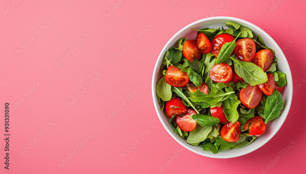 A fresh bowl of salad with cherry tomatoes and mixed greens on a vibrant pink background. Healthy eating concept. A fresh bowl of salad with cherry tomatoes and mixed greens on a vibrant pink background. Healthy eating concept.