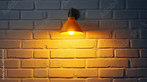 A sleek wall sconce mounted on a white brick wall in a modern loft apartment. The lamp emits a warm, yellow glow from within its shade, creating a cozy ambiance. 