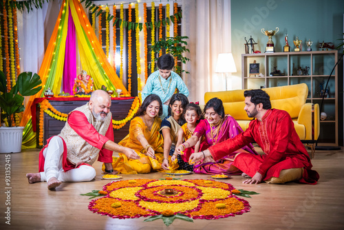 Indian family bonding over creating rangoli during Diwali or Ganesh festival celebration