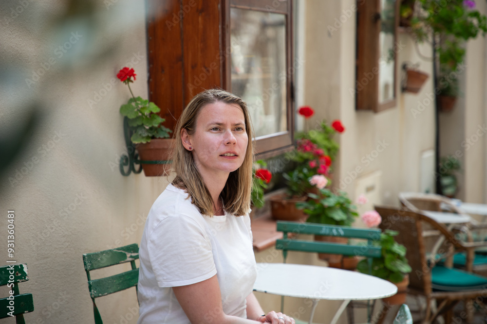young woman relaxing on a terrace in quaint village young woman relaxing on a terrace in quaint village