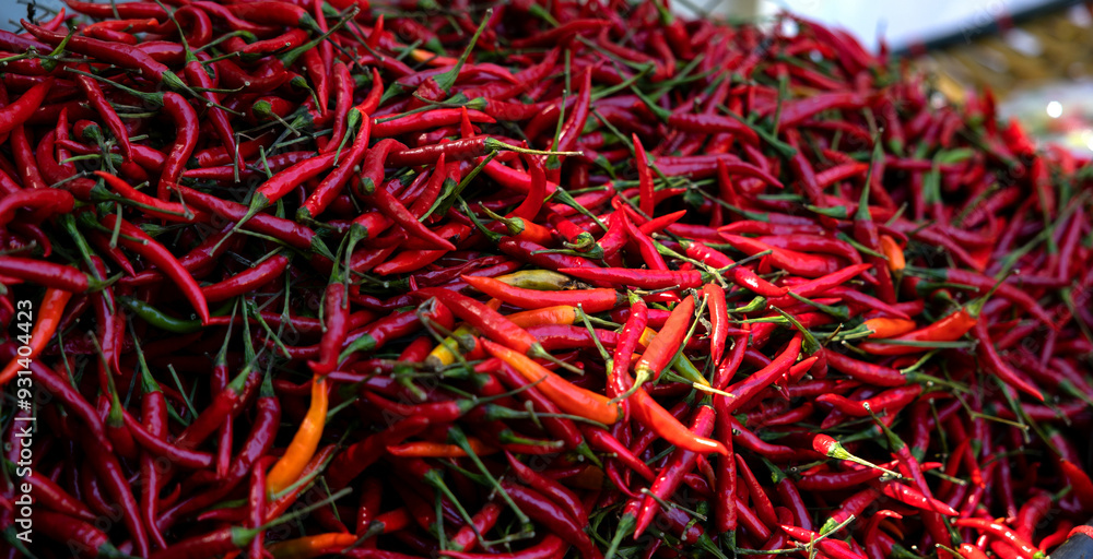 Naklejka premium A heap of chili peppers. Outdoors, market stall in the city. Exotic, vegetarian, ingredients, hot spice and vegetables.