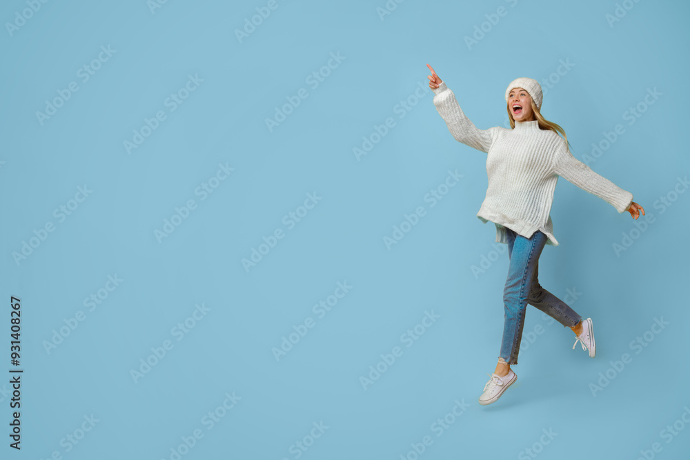 Magnetic offer. Excited winter girl pointing and running towards copy space, yellow background Magnetic offer. Excited winter girl pointing and running towards copy space, yellow background
