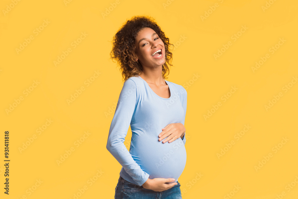 Excited african-american pregnant woman touching belly and laughing on white background Excited african-american pregnant woman touching belly and laughing on white background