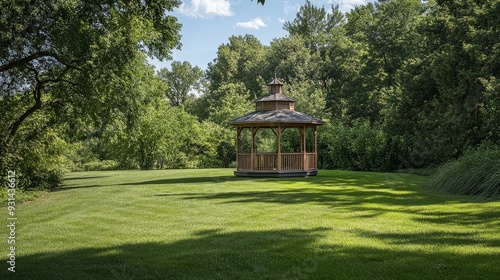 A scenic view of a large expanse of grass with a small, charming gazebo in the center.