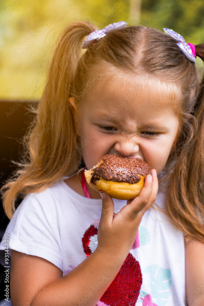 Little blonde girl eating chocolate donut. junk food, sweetness, children's joy. Little blonde girl eating chocolate donut. junk food, sweetness, children's joy.