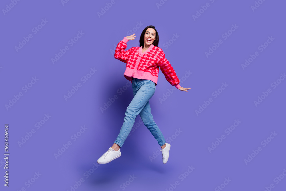 Full length photo of shiny attractive lady dressed pink cardigan jumping high empty space isolated violet color background Full length photo of shiny attractive lady dressed pink cardigan jumping high empty space isolated violet color background