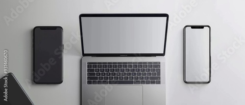 An image shows a laptop with blank screen, flanked by two smartphones. All devices are inactive on a clean, modern desk setting with unclear details.