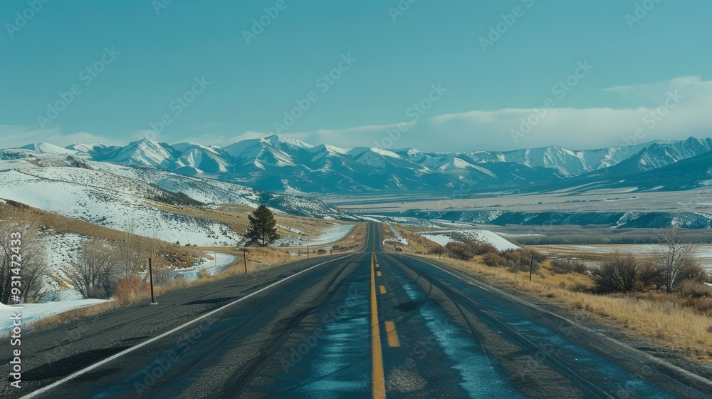 A desolate road extends toward the snow-capped mountains, framed by a cloud-filled sky, capturing the allure of winter's calm and beauty. A desolate road extends toward the snow-capped mountains, framed by a cloud-filled sky, capturing the allure of winter's calm and beauty.