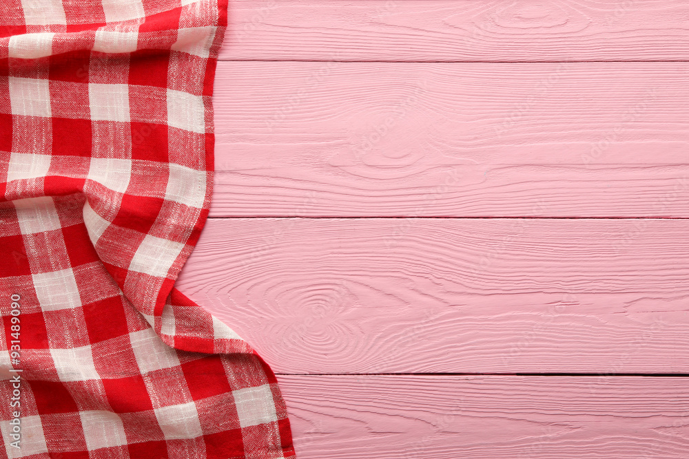 Red checkered picnic tablecloth on pink wooden table, top view. Space for text Red checkered picnic tablecloth on pink wooden table, top view. Space for text
