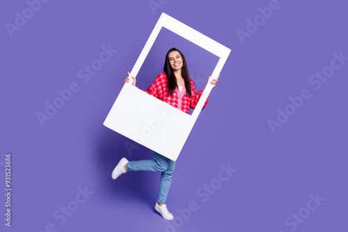 Full length photo of adorable lovely girl wear pink cardigan rising paper frame empty space isolated purple color background