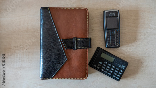 Obraz na plátně A vintage desktop scene  of a two tone brown leather Filofax, a mobile phone and