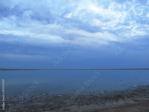 View of blue sky on the beach. A serene view of a tranquil sea at under a gradient sky transitioning from to blue