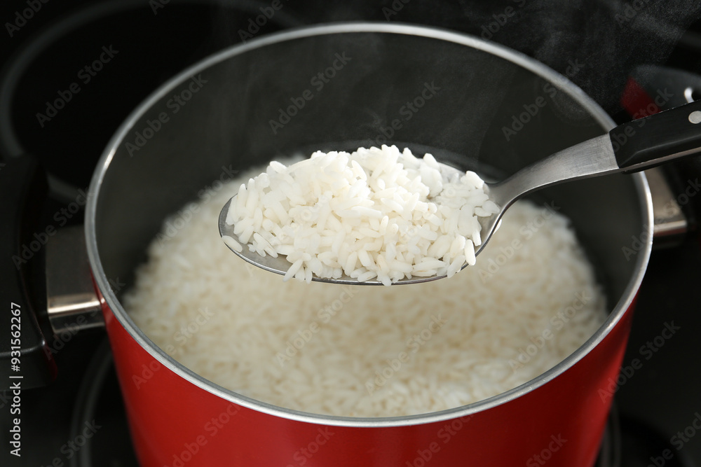 Taking boiled rice from pot with spoon, closeup Taking boiled rice from pot with spoon, closeup
