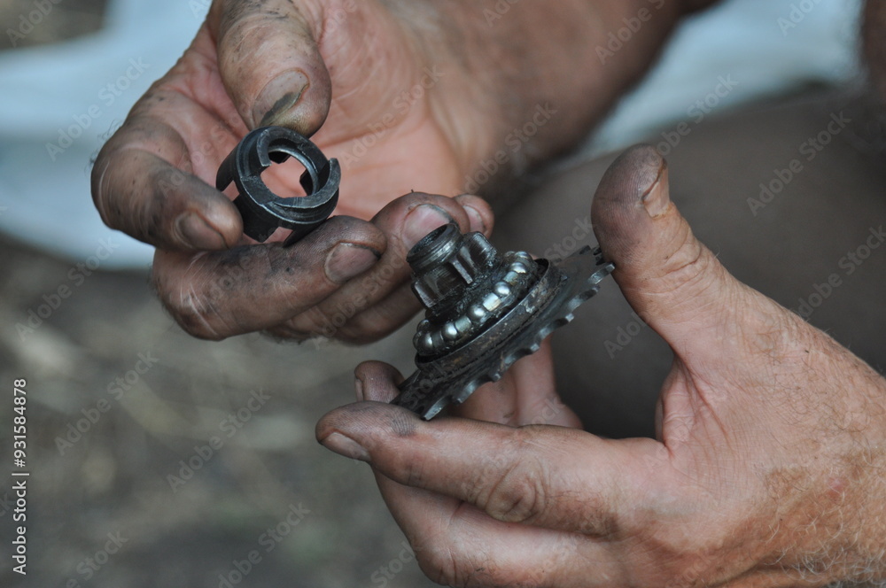 Fototapeta premium The man fixing his old bike. Process of replacing the rear sprocket of an old bicycle. Relaxing hobby and good time. 