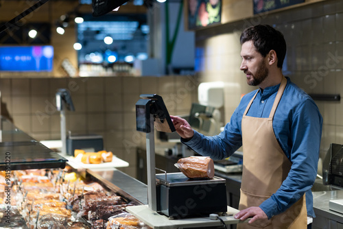 Принти на полотні Butcher working in grocery store using digital scales to weigh deli meats