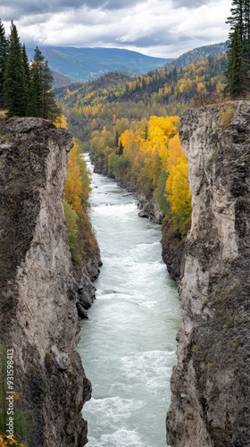 A tranquil river flows through Siberias taiga, flanked by rocks and surrounded by golden larch trees beneath a cloudy sky. photo