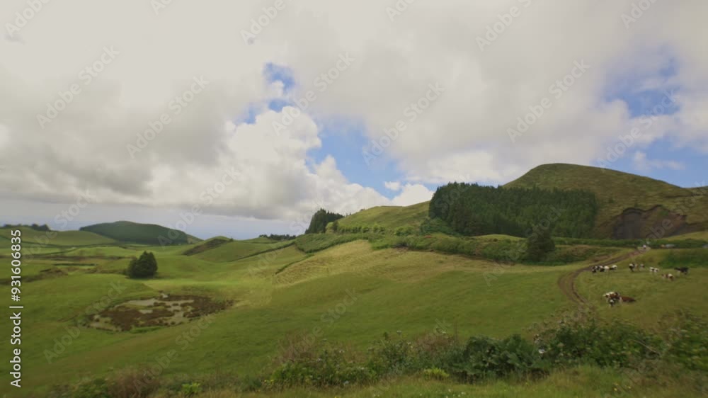 Clouds shifting gracefully over a serene green landscape Clouds shifting gracefully over a serene green landscape