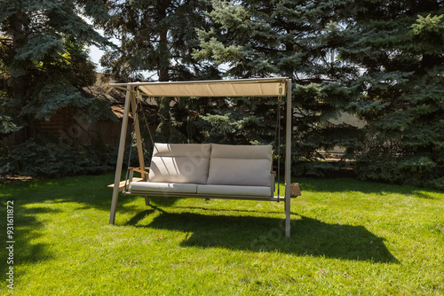 outdoor swing with a canopy on a green lawn