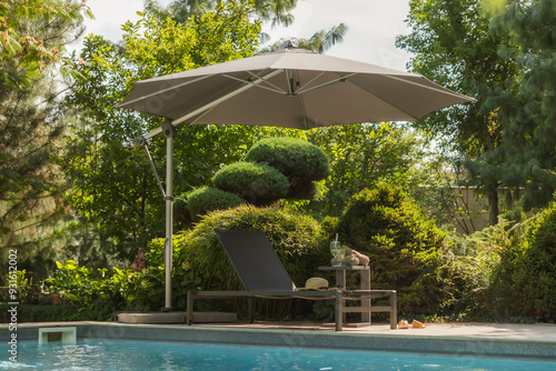 outdoor furniture sun umbrella pool trees background