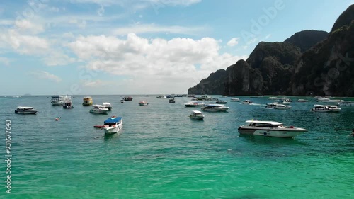 Many moored boats, waves, calm sea, Phi Phi islands, tour, turquoise water, sky. Coastline, mountain landscape, clear sky, tourism, speed boats, longtails, active recreation. High quality 4k footage