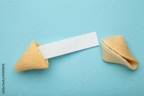 Photography Cracked traditional fortune cookie with prediction on blue background