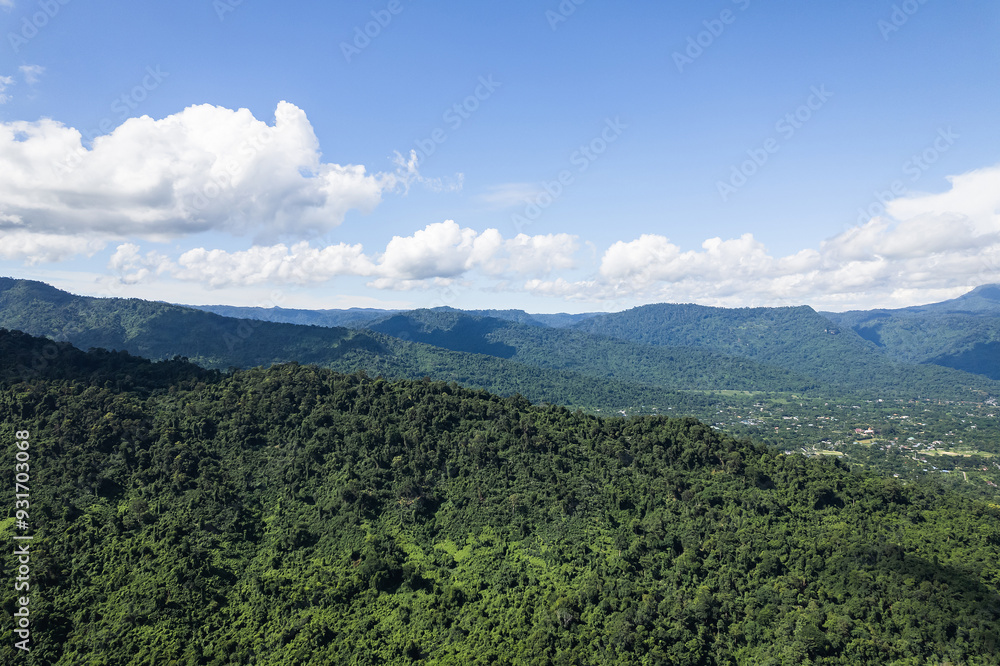 Beautiful aerial view of lush green forest and mountains under cloudy sky. Beautiful aerial view of lush green forest and mountains under cloudy sky.