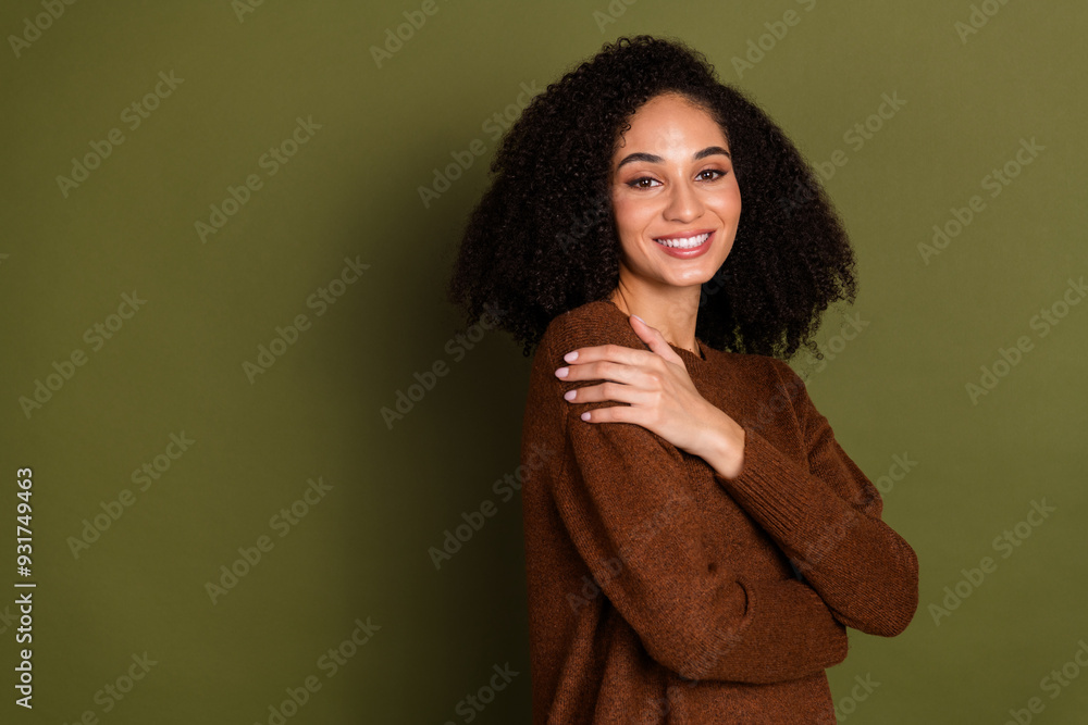 Portrait of pretty young woman touch shoulder empty space wear sweater isolated on khaki color background Portrait of pretty young woman touch shoulder empty space wear sweater isolated on khaki color background